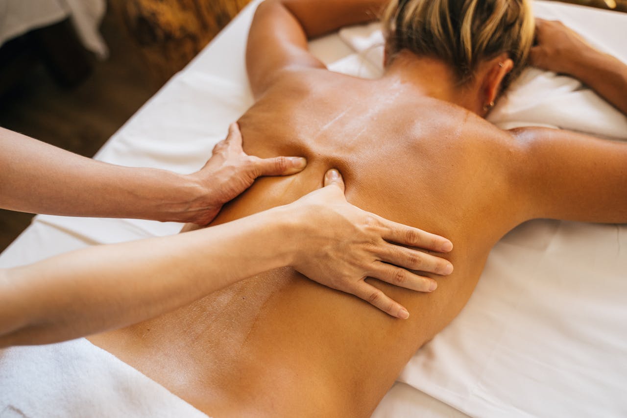 Close-up of a relaxing massage therapy session at a spa with focus on back and hands.